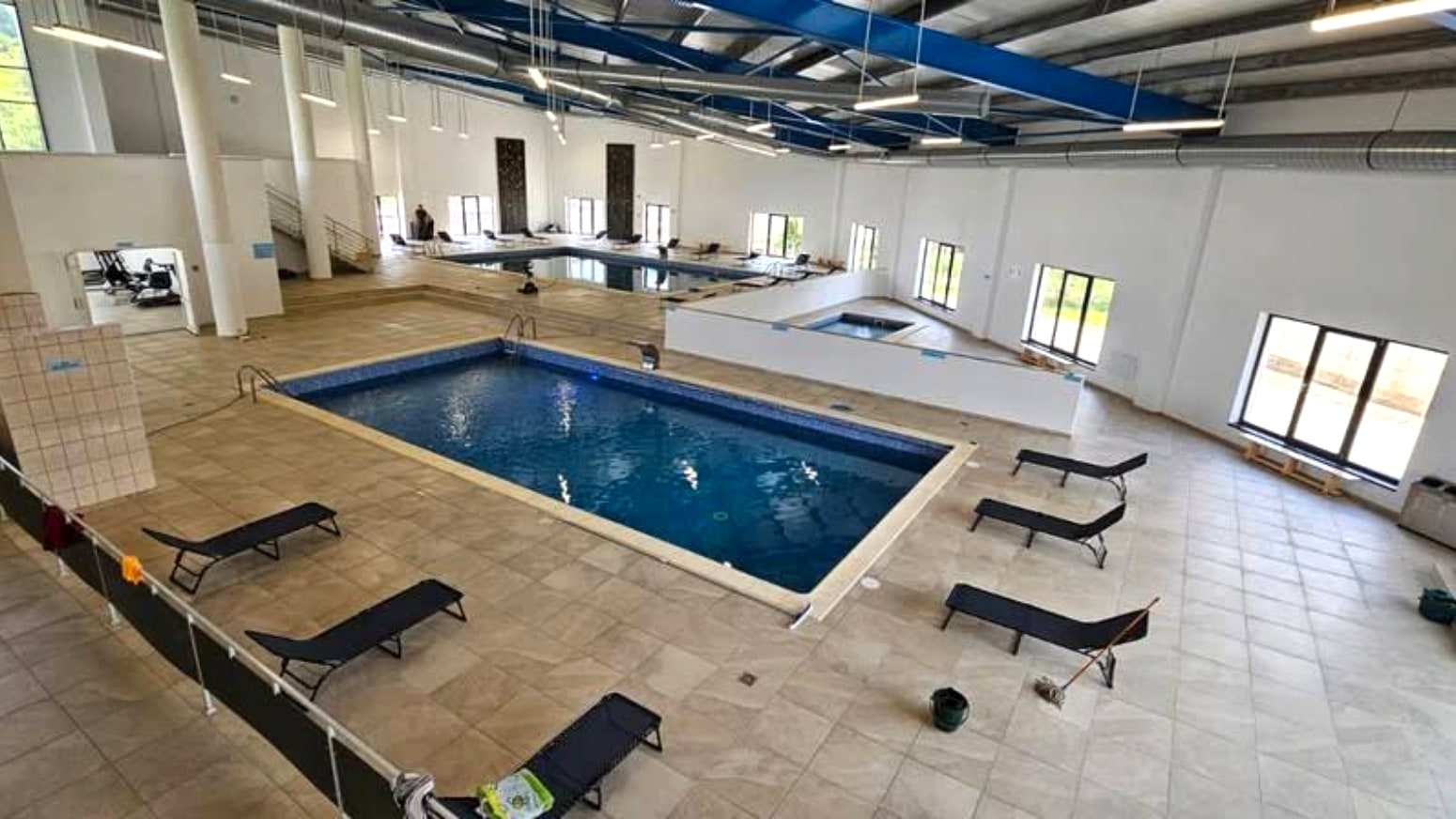Sala bazinului acoperit din Săliștea de Sus, cu grinzile albastre și ferestrele mari